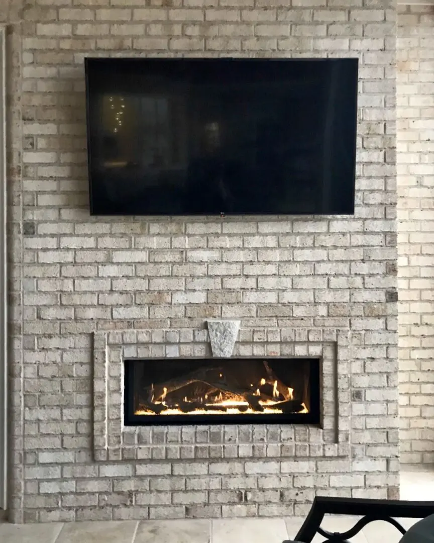 A fireplace with a flat screen tv mounted above it.
