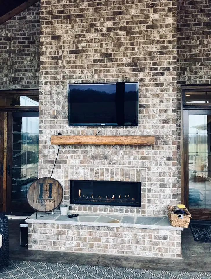 A fireplace with a television mounted on it