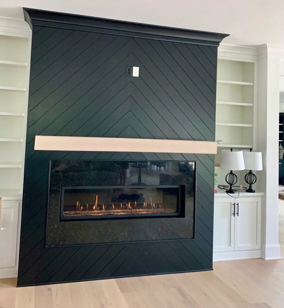 A fireplace with black painted walls and white trim.